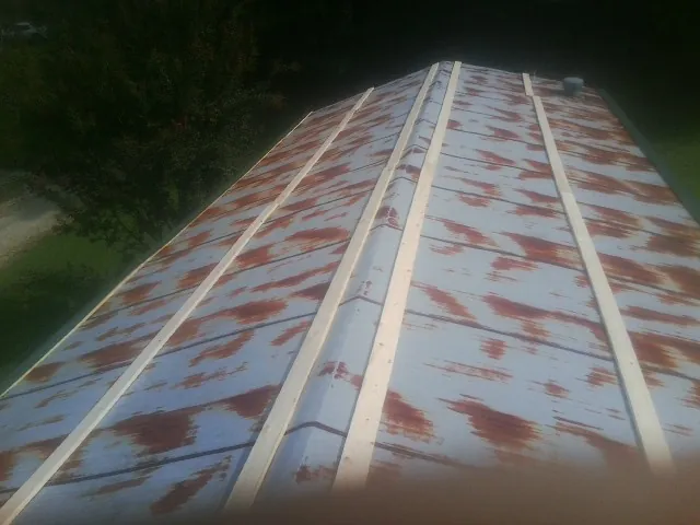 Rusted metal roof panels with new wood purlins before replacement — Storm Damage Roof Repair in New Bavaria by Roofing Brothers