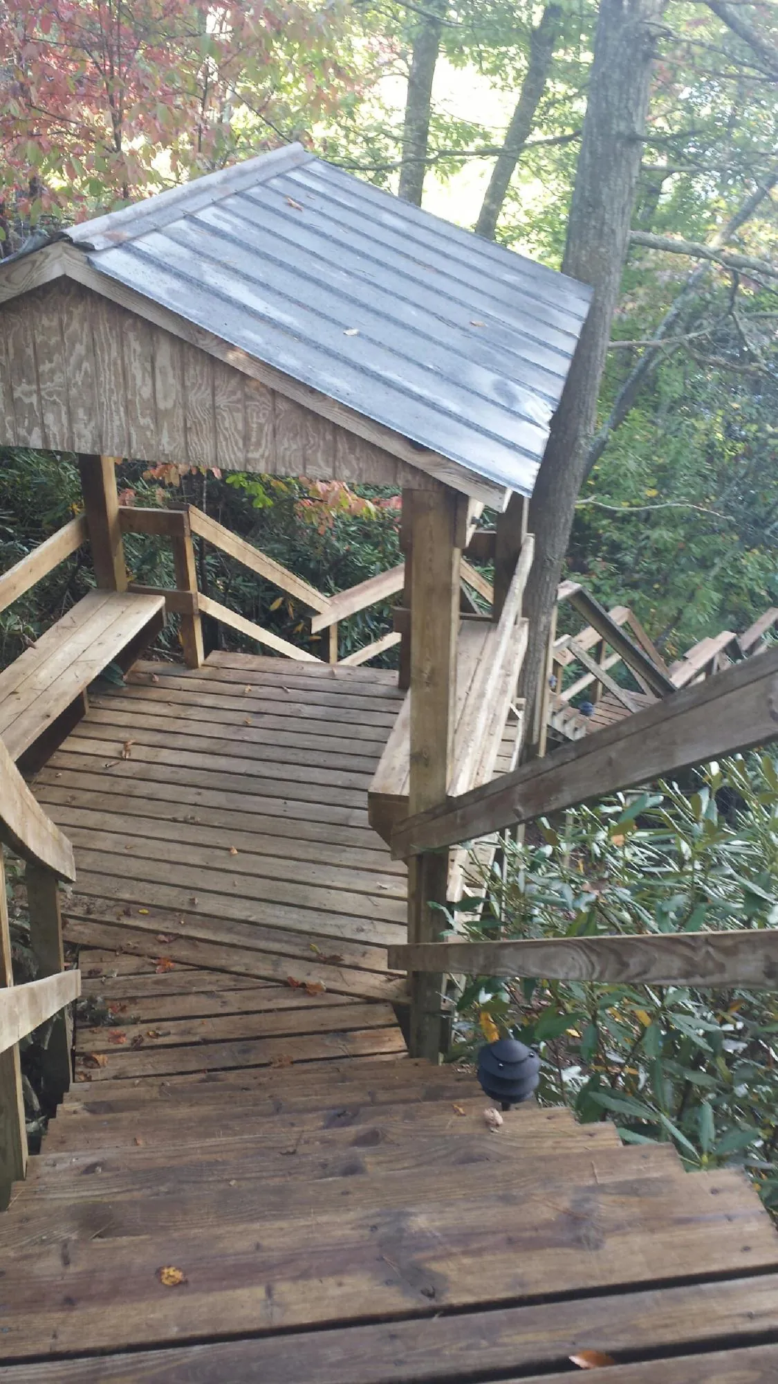 Metal roofed shelter over wooden steps on a wooded walkway — Skylight Repair & Installation work by our crew in New Bavaria