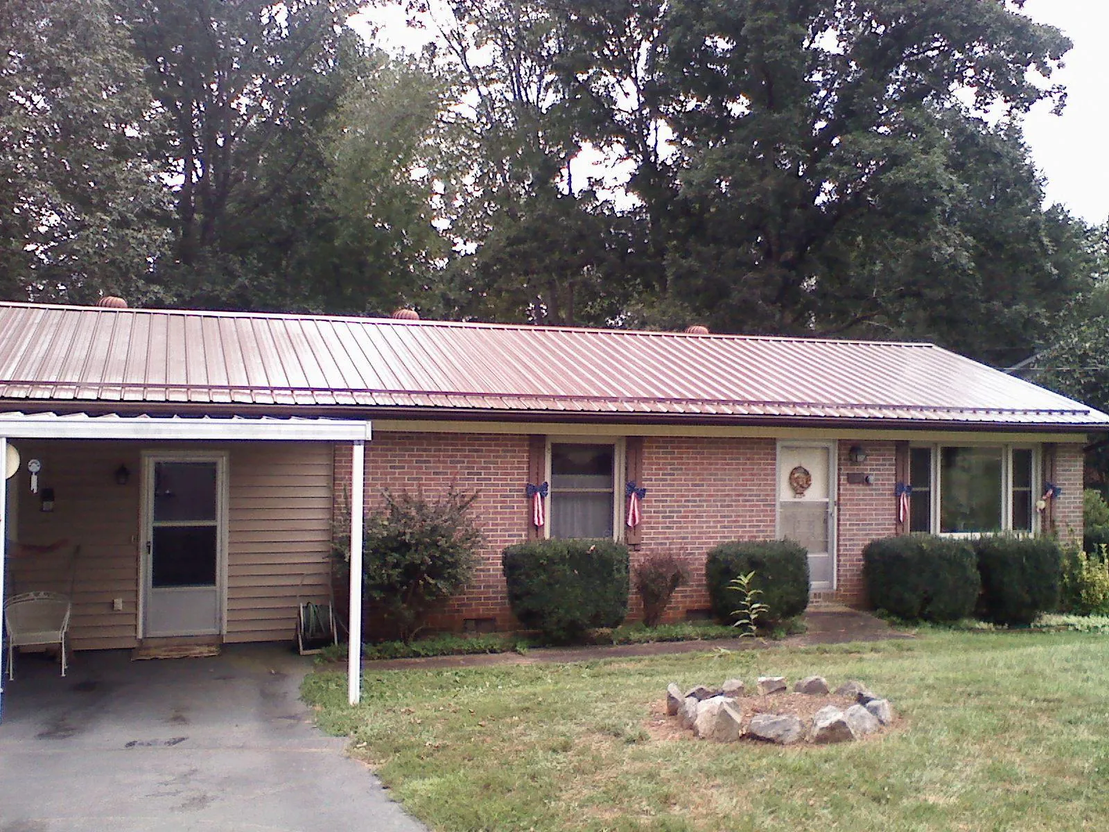 Bronze metal roof and carport on a brick ranch home — Roof Repair work by our crew in New Bavaria